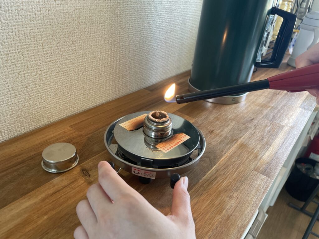 ライターを使ってアルポットの燃料タンクにあるガラス芯へ点火する手順