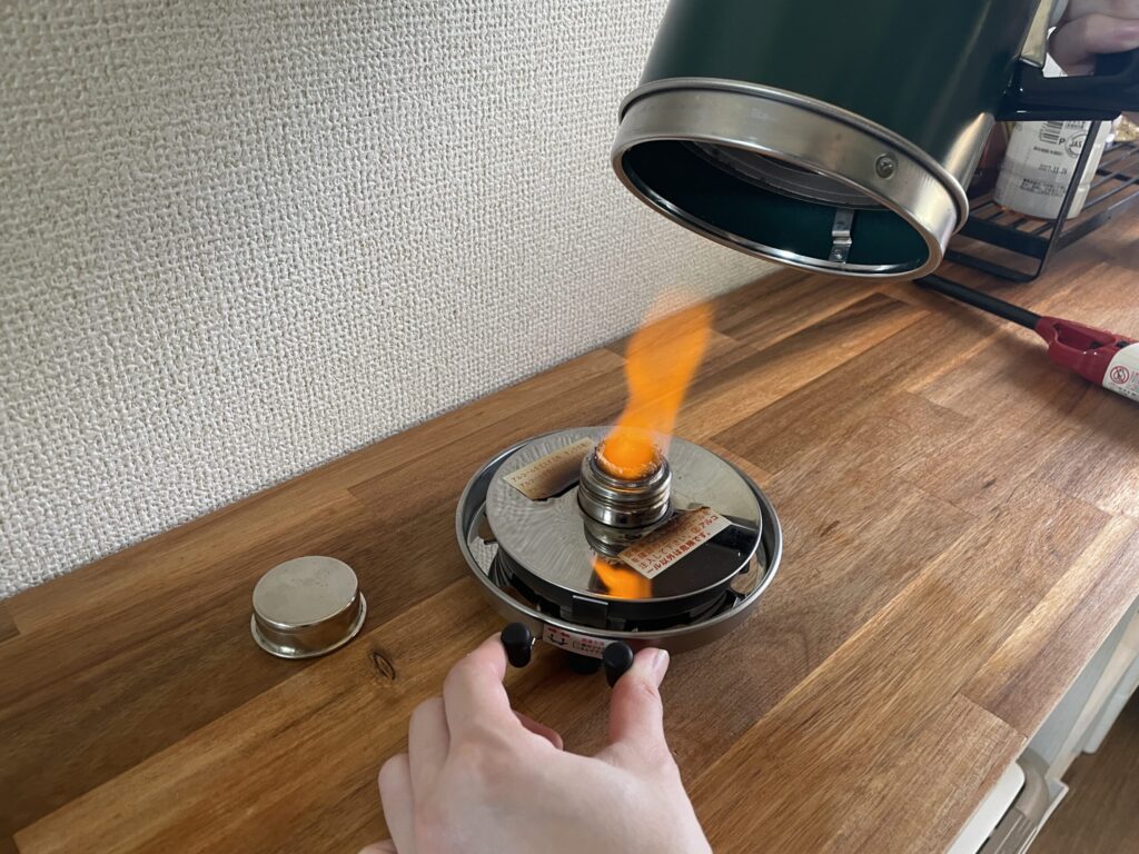 燃焼中のアルポット燃料タンクへ本体をかぶせて取り付ける手順