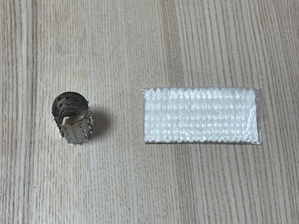 アルポットの芯押さえと交換前の新品ガラス芯(替え芯)を並べた状態